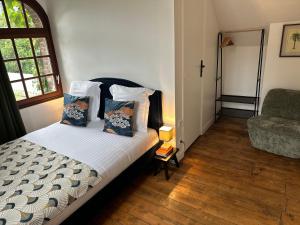 a bedroom with a bed and a chair and a window at Villa La Renaissance - Etretat in Étretat