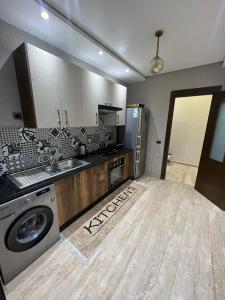 a kitchen with a washing machine and a washer at dar bouazza magnifique appartement avec piscines & espace détente in Dar Bouazza