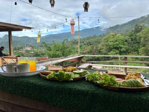 a table with food on it with a view of a mountain at รักเขาอินทนนท์โฮมสเตย์ Doi inthanon Homestay in Ban Yang Di Pha Mop