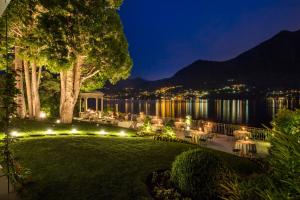 a garden with a view of the water at night at Grand Hotel Imperiale Resort & SPA in Moltrasio