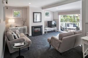 a living room with a couch chairs and a fireplace at Clarendon Cottages in Sassafras