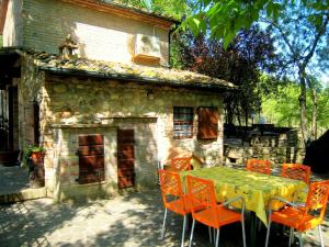 a table and chairs in front of a stone house at Montana Escape, Tuscan Stay in Chiusdino
