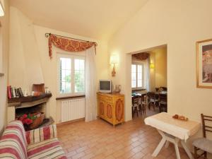 a living room with a couch and a tv and a table at Apartment in Umbria near Vineyards in Giano dellʼUmbria