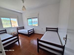a room with two beds and two windows at Villa Diki beach in Tangier