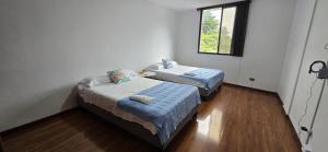 two beds in a small room with a window at Tequendama Amplio apto Cerca a clínicas in Cali