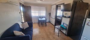 a living room with a blue couch and a table at Windana Cottages in Hawker