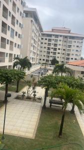 a park with palm trees and a large building at Apt Luar do Sertao in Aracaju