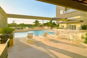 a patio with chairs and a swimming pool at Caribbean Ocean Breeze Beach Condo! in Juan Dolio