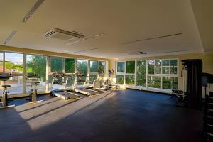 a gym with treadmills and machines in a room with windows at Caribbean Ocean Breeze Beach Condo! in Juan Dolio
