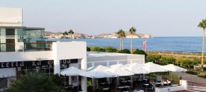 a building with white umbrellas in front of the ocean at cal'Nathalie in San Juan de los Terreros