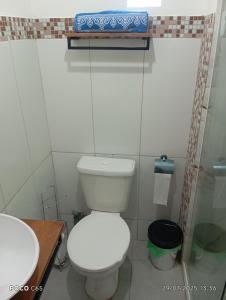 マンガラチバにあるPousada suite Praiaの白いトイレと洗面台のあるバスルーム