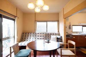 una sala de estar con una mesa y un sofá en Popotel Three Room Z, en Matsumoto