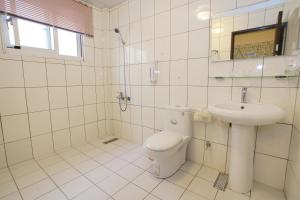 a white bathroom with a toilet and a sink at Bang Qiaonuo - Peng's family in Taitung City