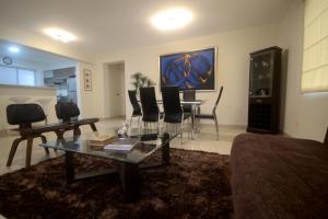 sala de estar con mesa de cristal y sillas en Luxury Apartments Miraflores, en Lima
