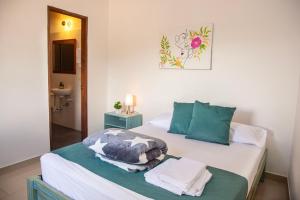 a bedroom with a bed with towels on it at Blomst Casa Hostal in Jericó