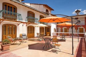 a patio with a table and chairs and umbrellas at San Sebastian Hotel Boutique in Huaraz