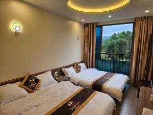 a hotel room with two beds and a window at ZingHome Hà Giang in Ha Giang