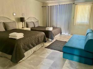a hotel room with two beds and a couch at Condominio en el corazon de San carlos in San Carlos +34 photos