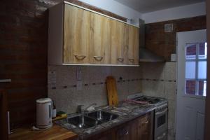 a kitchen with wooden cabinets and a sink at Apart-Maragato in Patagones +1 photo