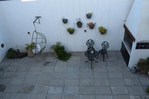 two chairs sitting on a patio with potted plants at Apart-Maragato in Patagones