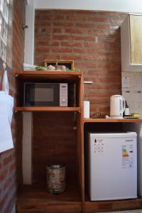 a kitchen with a microwave on a shelf and a refrigerator at Apart-Maragato in Patagones