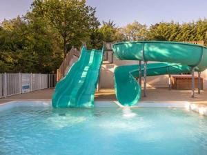 a green water slide in a swimming pool at Mobil-home avec terrasse à Bretignolles-sur-Mer, 6 pers., 3 chambres - API-1-52-389 in Brétignolles-sur-Mer