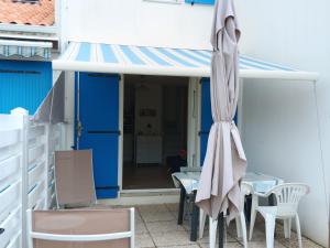 a patio with an umbrella and a table and chairs at Maisonnette 4 pers, proche plage et commerces, parking - FR-1-476-247 in La Faute-sur-Mer
