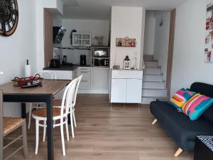a kitchen and living room with a table and a couch at Maisonnette 4 pers, proche plage et commerces, parking - FR-1-476-247 in La Faute-sur-Mer