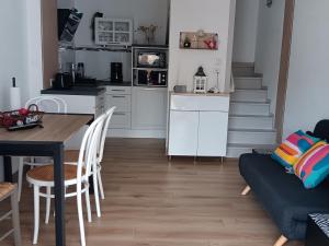 a kitchen and living room with a table and a couch at Maisonnette 4 pers, proche plage et commerces, parking - FR-1-476-247 in La Faute-sur-Mer