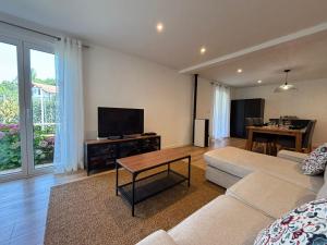 a living room with a couch and a flat screen tv at Belle maison 10 pers, piscine et jardin à Urrugne - FR-1-239-1146 in Urrugne