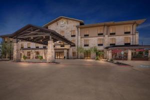 a large stone building with a parking lot at Sleep Inn & Suites in Dripping Springs