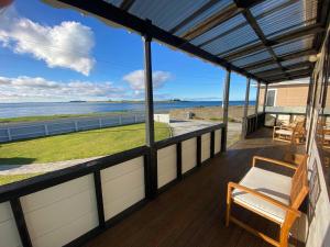 a porch with a bench and a view of the ocean at Waterfront Cottage Bluff in Bluff