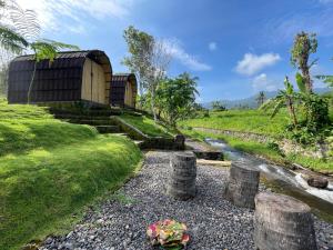 a small building on a hill next to a river at Tranquil Riverside Camping in Ambengan