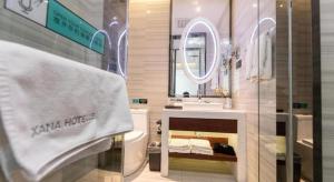 een badkamer met een wastafel, een toilet en een spiegel bij Xana Hotelle Xi'an GONG IP South Gate of Zhonglou in Xi'an +244 foto's