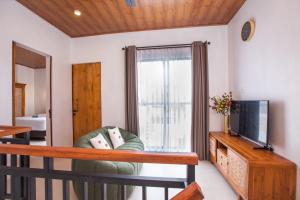 a living room with a tv and a chair at 3 Bedrooms Private Villa & Pool Near GWK-ER House in Jimbaran