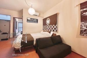 a bedroom with a bed and a couch at Senjushuku FUJI 101 北千住 in Tokyo