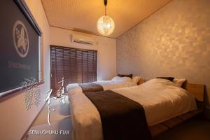 a bedroom with two beds and a window at Senjushuku FUJI 101 北千住 in Tokyo