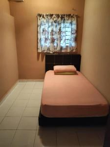 a small bed in a room with a window at Homestay LubokSawah in Pekan Nanas