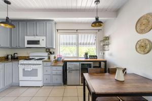 a kitchen with white appliances and a wooden table at Chic Abode In Central Berkley in Berkeley