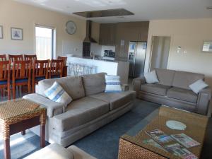 a living room with a couch and a kitchen at Residence On Robe in Robe