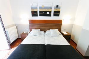 a bedroom with a large bed with two pillows at Hostal San Ignacio Centro in San Sebastián