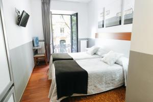 a hotel room with a bed and a window at Hostal San Ignacio Centro in San Sebastián