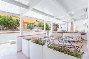 een balkon met tafels, stoelen en bloemen bij Suite Faro 33 in San Vito lo Capo