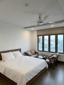 a bedroom with a bed and a ceiling fan at Wind Homestay & Apartment in Danang