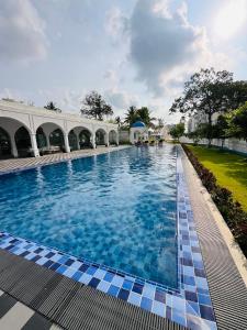 a large swimming pool in a building with blue tiles at Celestial Negombo Serviced Pool View Apartment in Negombo