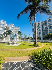 a park with a palm tree and a building at Celestial Negombo Serviced Pool View Apartment in Negombo