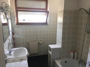 a bathroom with a sink and a toilet and a window at Ponente Central Apartment in Senigallia