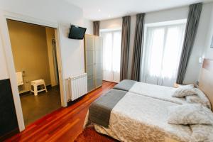 Łóżko lub łóżka w pokoju w obiekcie Hostal San Sebastian Centro