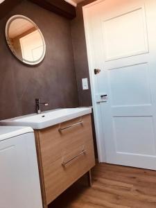 Un baño con un lavabo blanco y un espejo. en Le Rustique Apartement, en Morteau 5 fotos más