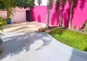 Un edificio rosa con una palmera en un patio. en Adults Only Casa Cactus - Stylish Boho Studios with Garden and Pool Access, en Puerto Escondido 16 fotos más